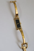Load image into Gallery viewer, Gold bracelet with a black face on a light gray background